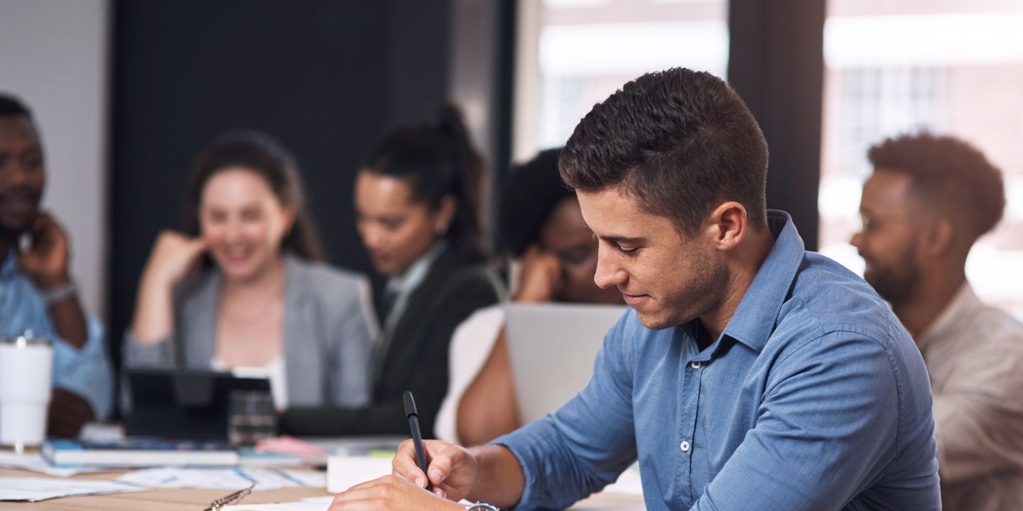 Man writing during office meeting