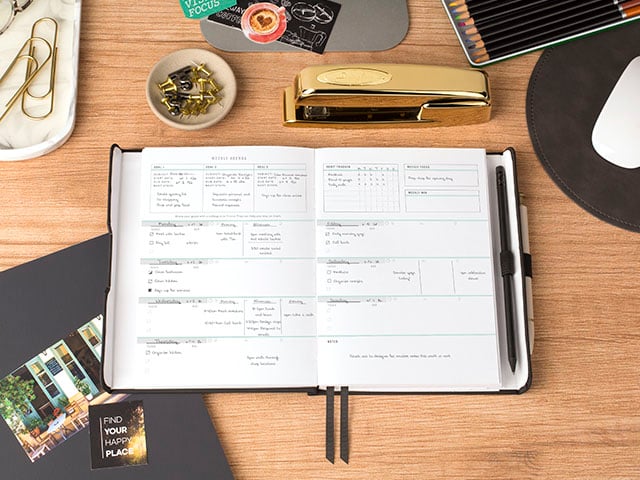 FOUNDATION planner on modern desk setting with magazine clippings and colored pencils