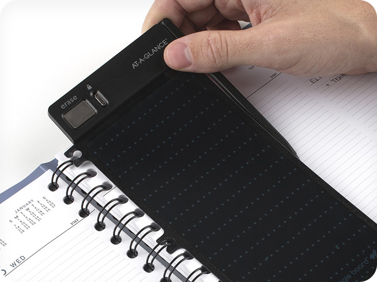 Hand snapping rewritable bookmark into planner